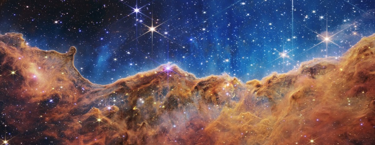 The Carina Nebula, an orange gaseous mass, with stars behind it.