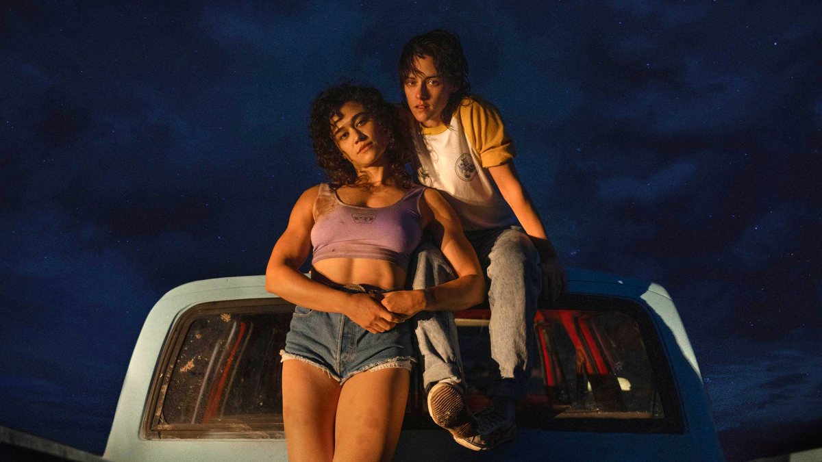 Two women sit in the back of a truck at night in 'Love Lies Bleeding.'