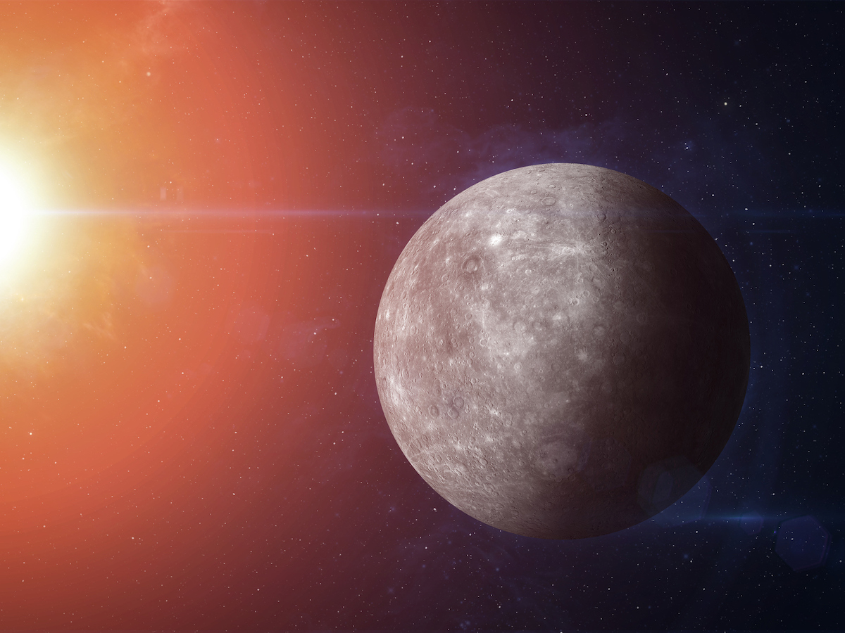The planet Mercury in the foreground, with the sun shining on it in the top left corner.