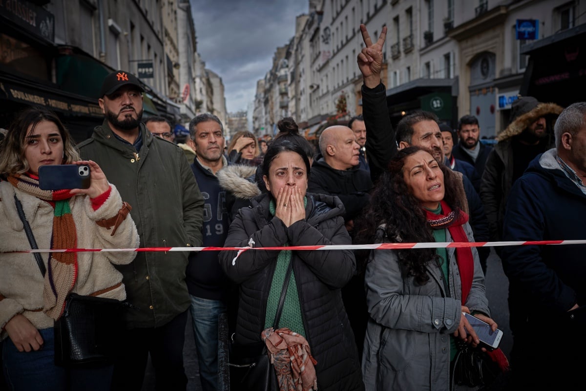 PARIS, FRANCE - DECEMBER 23: The local community watch in shock at the scene of a fatal shooting in the multi-cultural neighbourhood of Strasbourg-Saint Denis in Paris which left three dead and several people injured on December 23, 2022 in Paris, France. Police detained a 69-year-old man in connection with the attack, which took place in the 10th district, not far from Gare de l'Est station and a Kurdish cultural center. (Photo by Kiran Ridley/Getty Images)